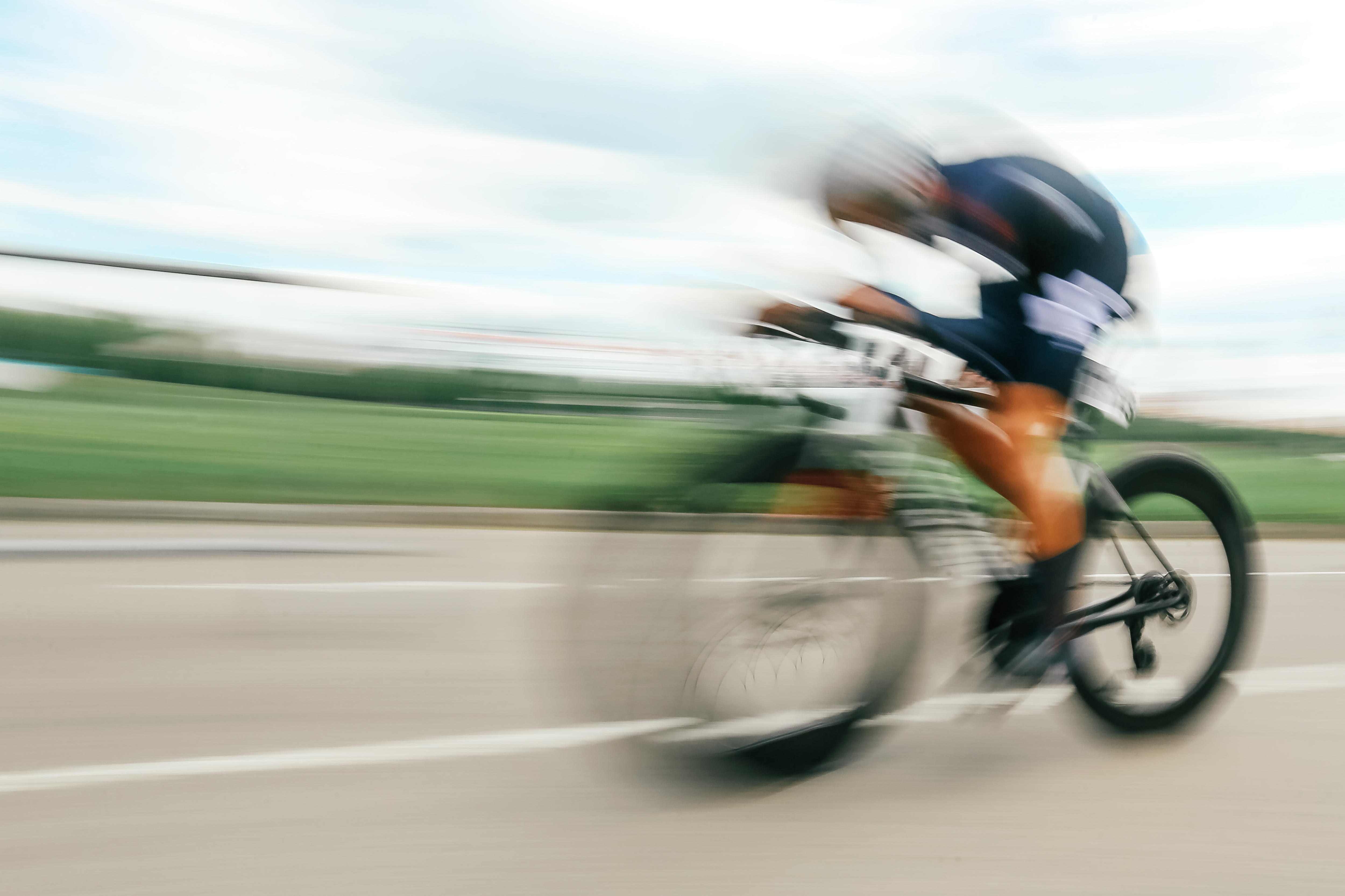 Un ciclista pasa junto a la cámara con una imagen borrosa. 
