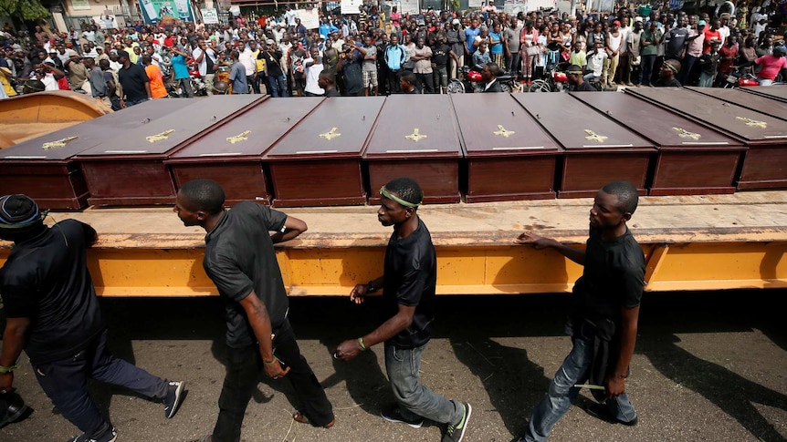 A truck carries coffins of people killed by herdsmen