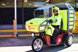 Postman Craig Patrick riding a three wheel electric vehicle