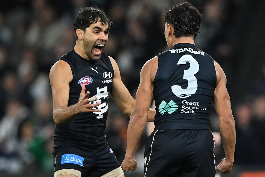 Two Carlton AFL players celebrate a goal against Port Adelaide.
