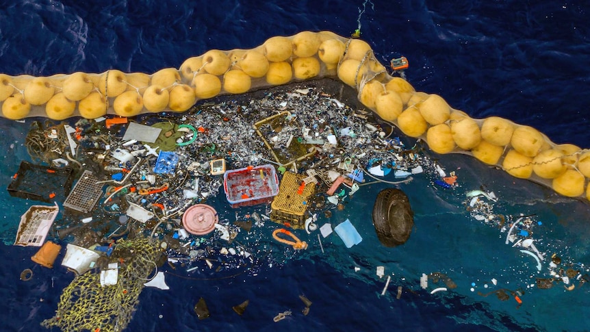 Floating plastic is collected on the ocean's surface by a row of floating corks