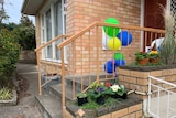 Balloons tied to a banister outside a brick house which was the site of a carbon monoxide incident in South Hobart.
