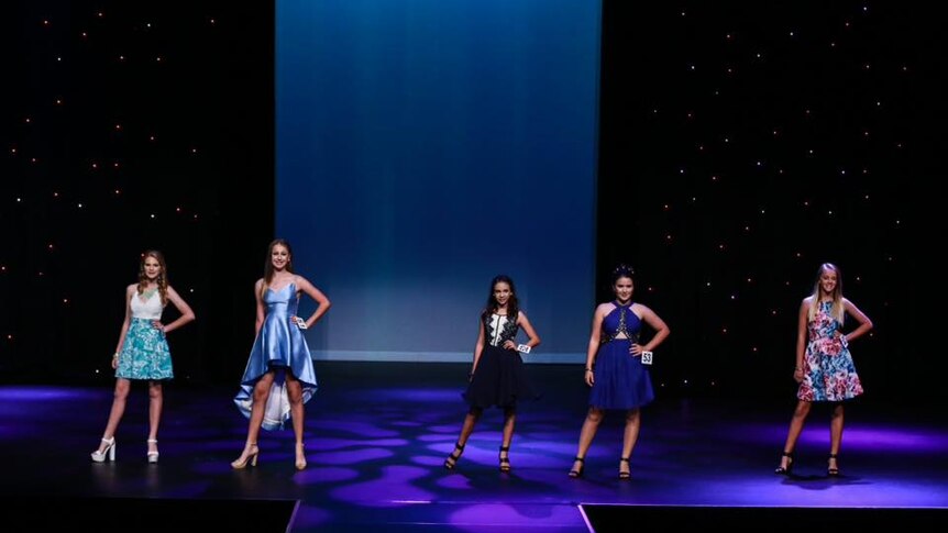 Dakota Lee stands on stage with four other teenage models at a competition in Mackay.