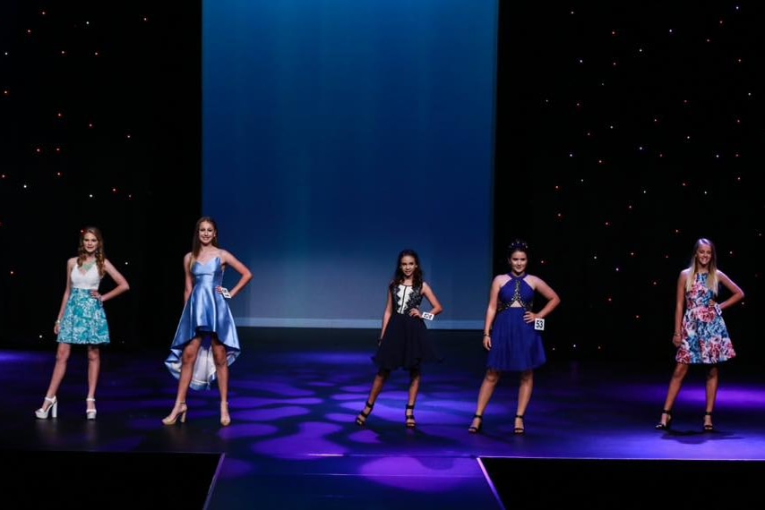 Dakota Lee stands on stage with four other teenage models at a competition in Mackay.