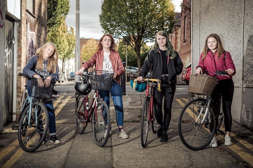 a group of women standing with bikes on a street in Ireland