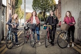 a group of women standing with bikes on a street in Ireland