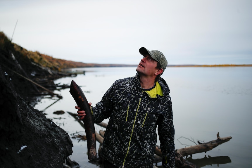 Nikita Zimov holds up a piece of a mammoth's tusk found in the Kolyma river