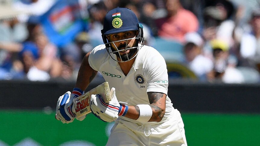 Virat Kohli stares after the ball as he drives down the ground and sets off for a run at the MCG