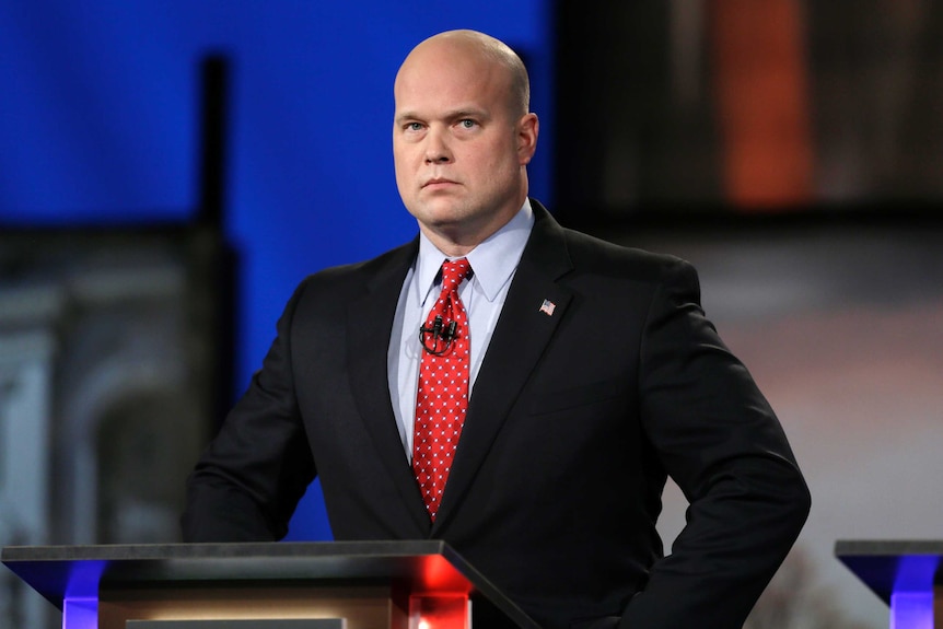 Matt Whitaker watches before a live televised debate in Johnston, Iowa in this file photo from 2014. He has a shaven head.