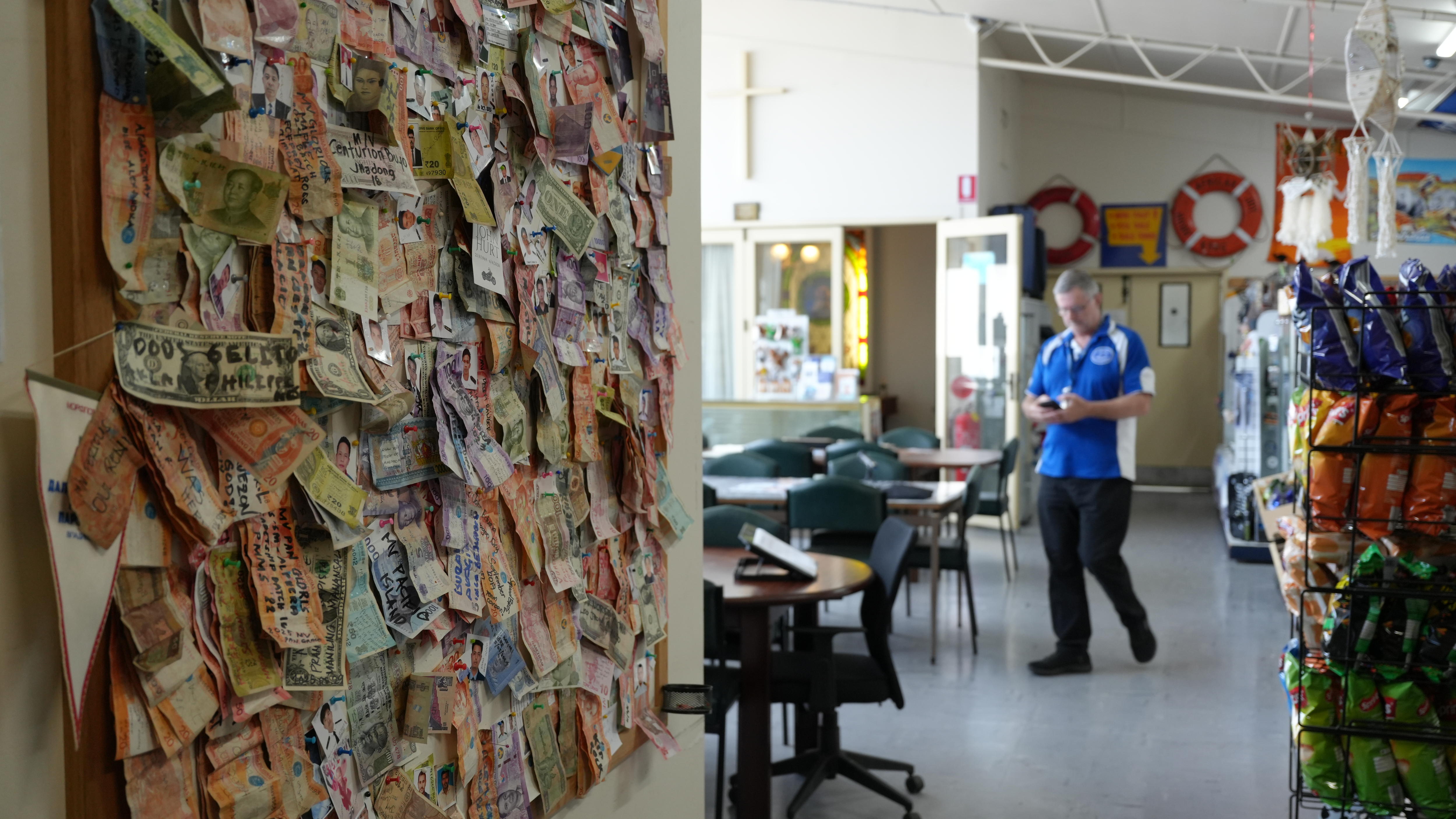A corkboard with banknotes pinned to it.