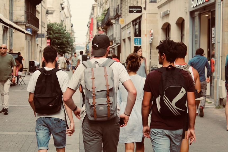 Teenage boys walk together in a line.