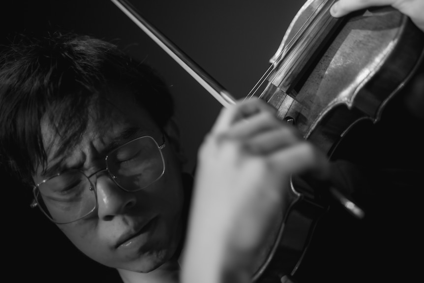 Eddy Chen close up playing violin, black and white.