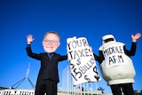 An activist wears a mask depicting Australian Prime Anthony Albanese. Another is dressed as a gas bottle