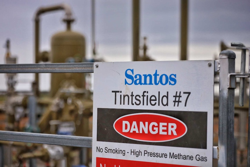 A "danger" sign in front of a gas well.