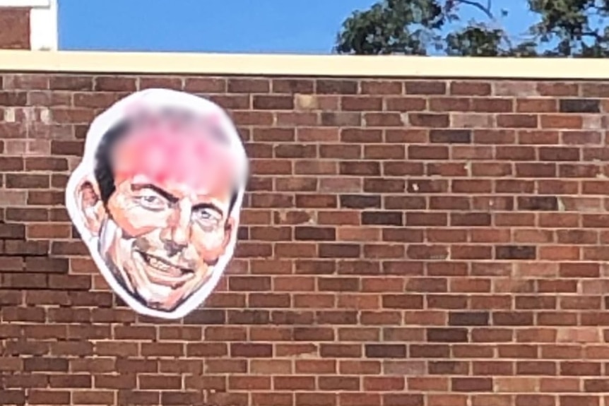 A caricatured head of Tony Abbott emblazoned with offensive language in Sydney.