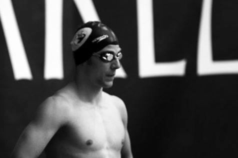A black and white photo of a swimmer wearing a cap and goggles.