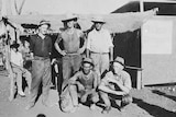 Miners standing in front of a tent