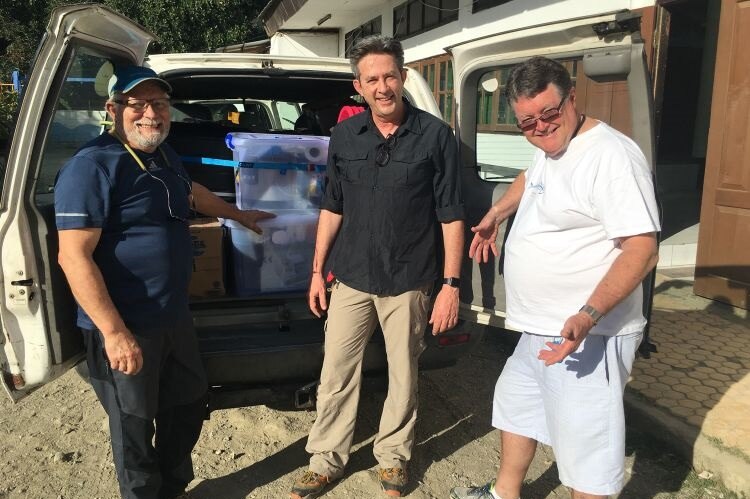 Dr Mark Tuffley, Dr John Fisher and Dr Malcolm Campbell load dental equipment in a vehicle to treat children in East Timor.