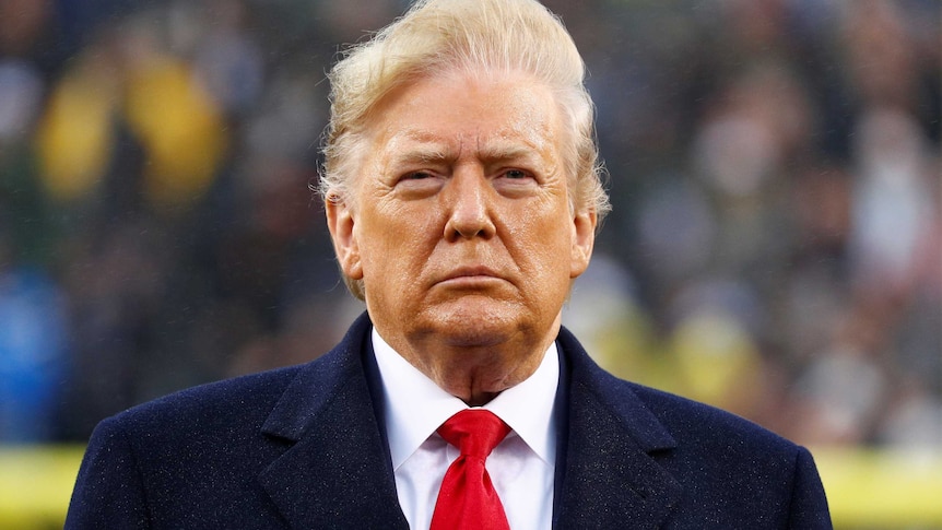 Donald Trump stands during the playing of the national anthem, December 14, 2019.