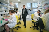 Rufus Black stands in centre of science lab, surrounded by students.