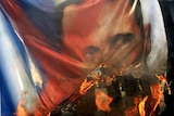 Protesters burn Assad banner