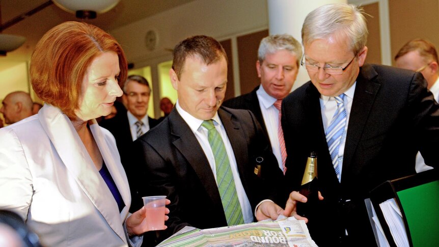 Prime Minister Julia Gillard, backbencher Graham Perrett and Foreign Minister Kevin Rudd check the race guide