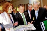 Prime Minister Julia Gillard, backbencher Graham Perrett and Foreign Minister Kevin Rudd check the race guide