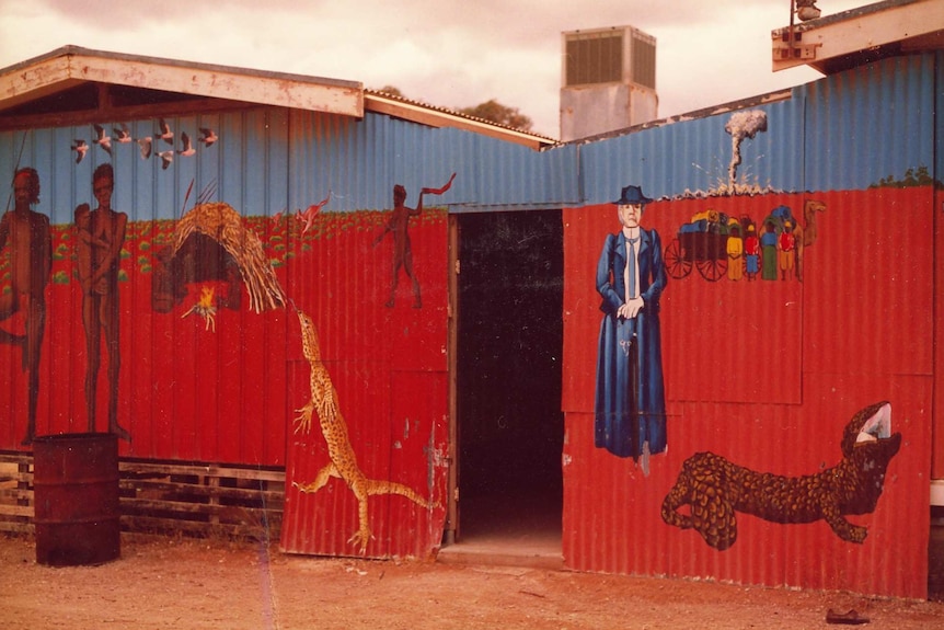 A colourful mural showing a well-dressed white woman, a nuclear blast, an Indigenous family and cameleers.