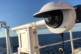 A robot that resembles a CCTV camera is attached to the front of a research vessel. 