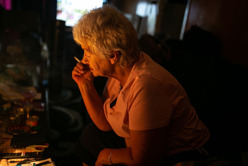 Cheryl in the dark with a cigarette.