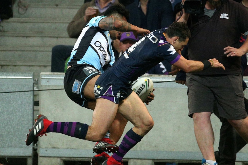 The Storm's Billy Slater (R) knocks Cronulla's Sosaia Feki out of play in the NRL preliminary final.