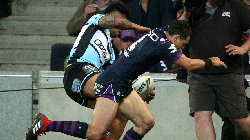 The Storm's Billy Slater (R) knocks Cronulla's Sosaia Feki out of play in the NRL preliminary final.