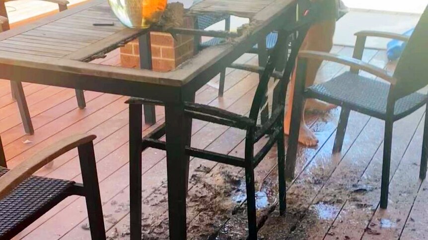 a glass vase atop burnt outdoor furniture.