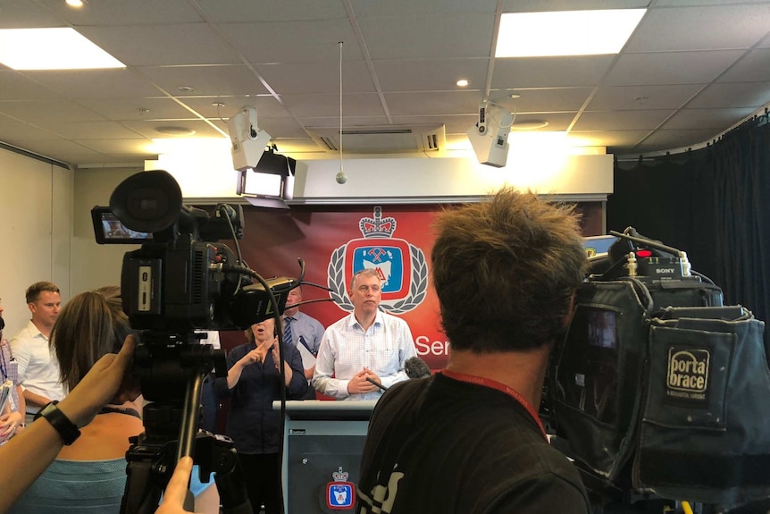 Tasmanian meteorologist Simon McCulloch briefs the media in front of a Tasmania Fire Service banner.