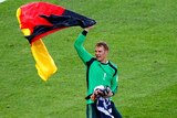 Germany goalkeeper Manuel Neuer celebrates with a German flag after defeating Argentina 1-0 in extra time.