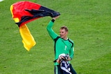 Germany goalkeeper Manuel Neuer celebrates with a German flag after defeating Argentina 1-0 in extra time.