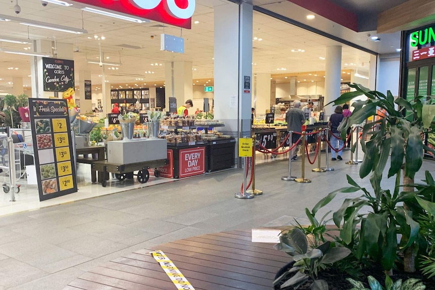 Queue line and closed-off seating at Coles supermarket at Westfield Garden City shopping centre in Brisbane.