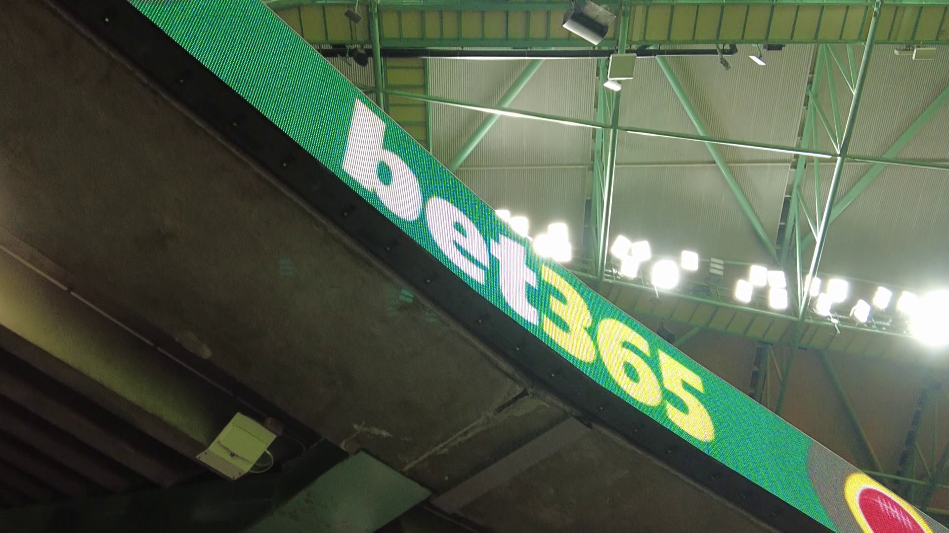 Branding for the betting company 'bet365' on an electronic billboard on part of a stadium at an AFL game.