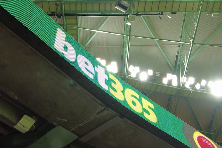 Branding for the betting company 'bet365' on an electronic billboard on part of a stadium at an AFL game.
