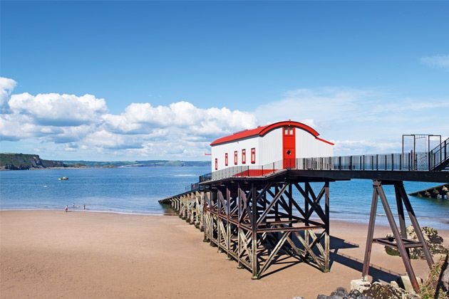 A house built on a boardwalk at a beach in Tenby, Wales.