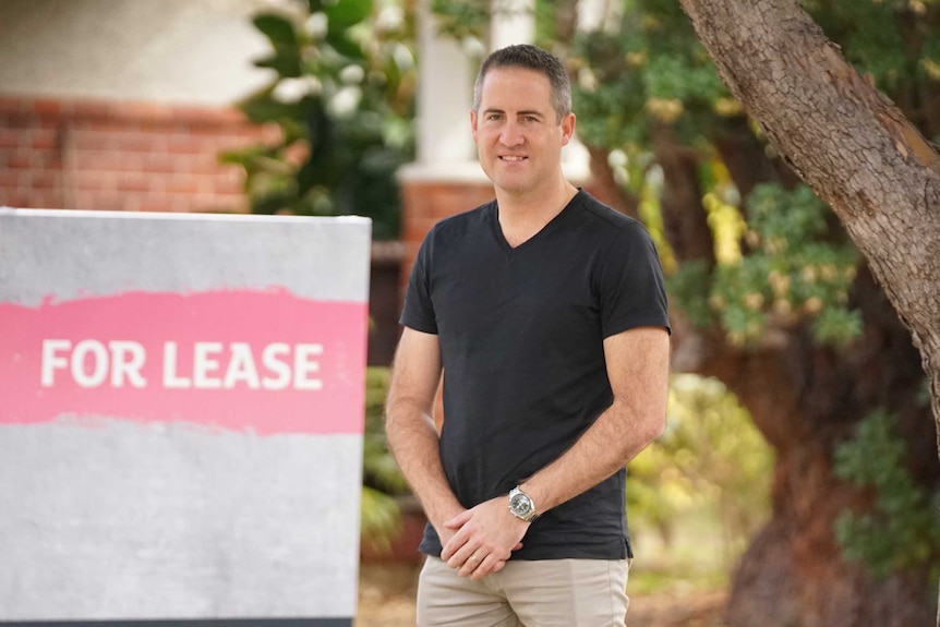 A man standing in front of a For Lease sign