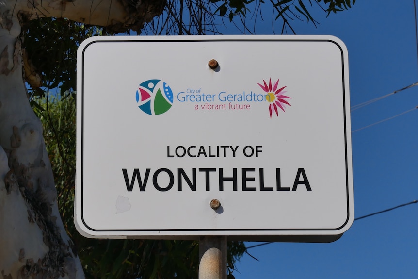 A sign reading "Locality of Wonthella" is in the foreground. A tree and power lines are in the background.