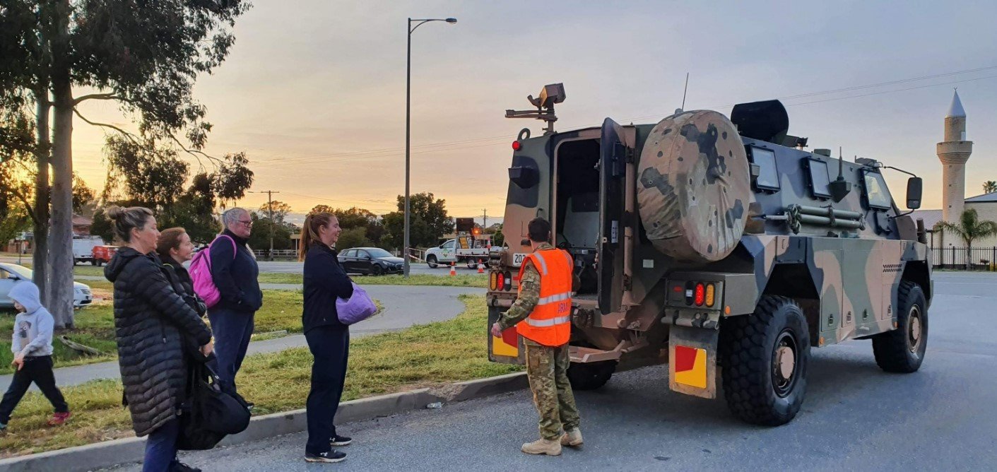 people standing next to an army vehicle