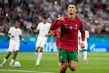 Cristiano Ronaldo winks and points down with his hand