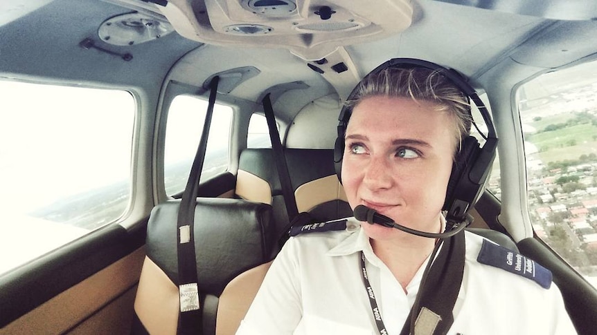 Young woman in pilot uniform flying plane