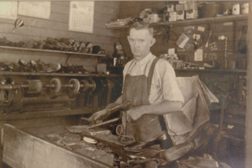 A black and white image of Steve Simpson making shoes in the 1900s 