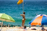Woman wearing bikini on the beach with umbrellas