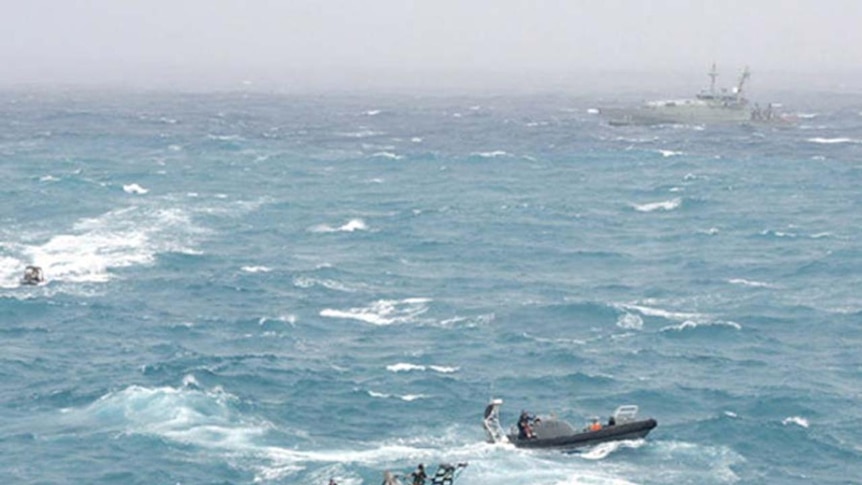 Sailors try to rescue asylum seekers whose boat crashed onto rocks