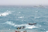 Navy boats try to rescue asylum seekers.