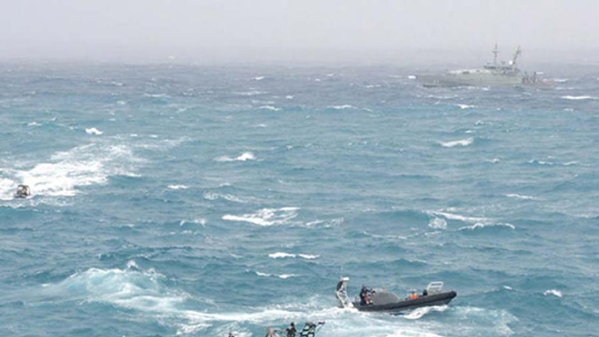 Sailors on Navy boats try to rescue asylum seekers whose boat crashed onto rocks on Christmas Island.